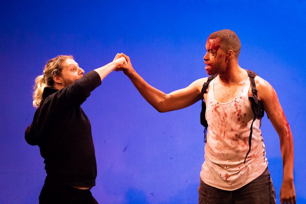 Matt Pick as Karl and Wade F. Wilson as John McClane (covered in our no-stain stage blood recipe) in Theatre Unleashed's award-wining production of A Very DIE HARD Christmas, presented at studio/stage for the 2018 Hollywood Fringe Festival. Directed by Gregory Crafts. Photo by Matt Kamimura